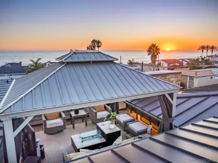 a view of a roof deck with couches and sky view