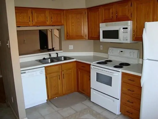 a kitchen with granite countertop a sink stove and microwave