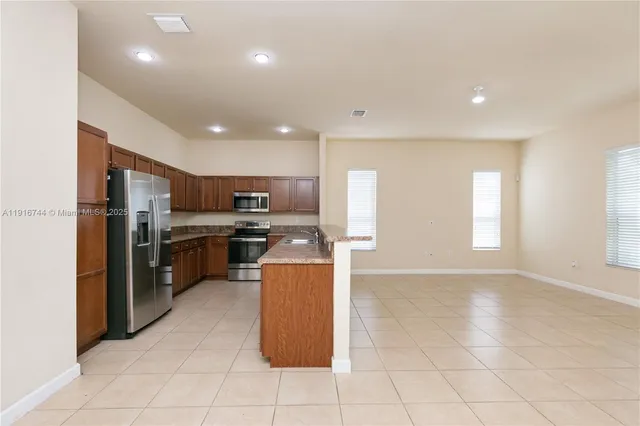 a kitchen with stainless steel appliances granite countertop a refrigerator stove and sink