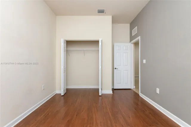 a view of a small space with wooden floor and a window