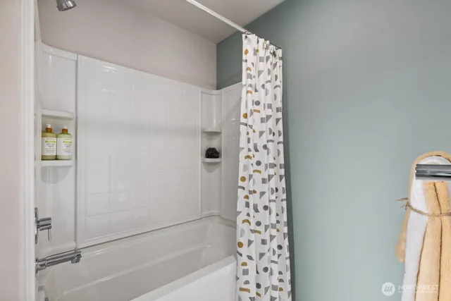 a bathroom with a shower curtain and a window