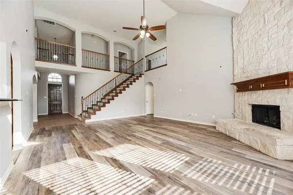 a view of a livingroom with wooden floor and a fireplace