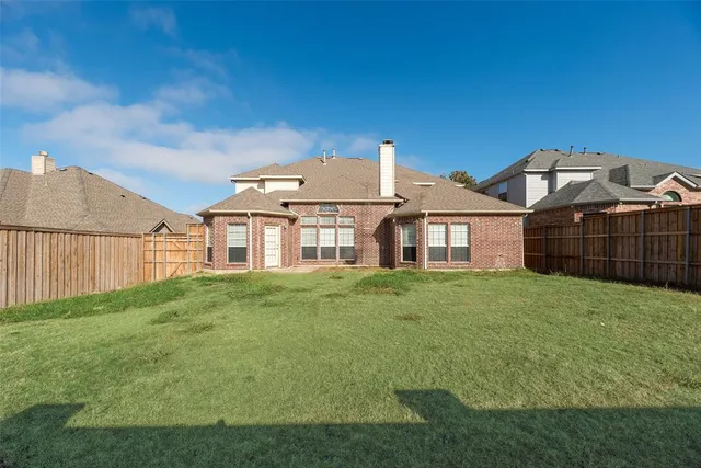 a view of a big house with a big yard and large trees