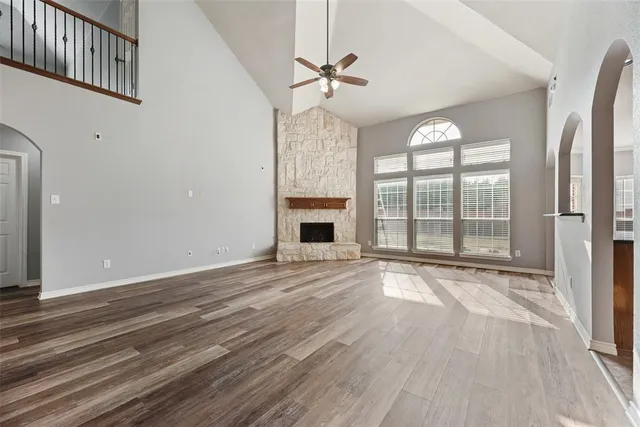 a view of an empty room with a fireplace and a window