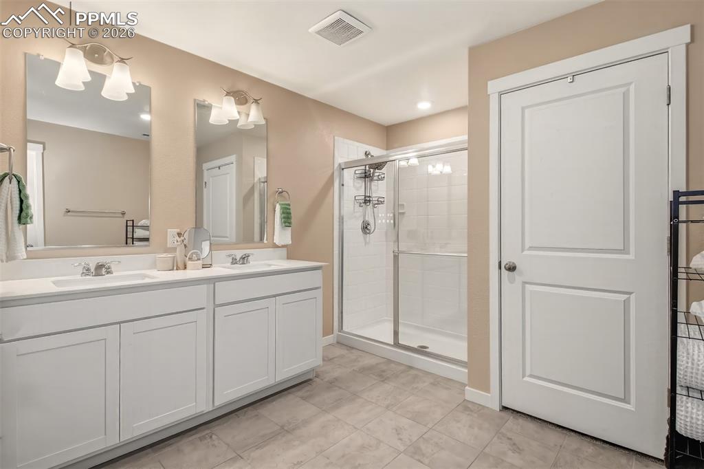 6133 Alpine Ridge Drive Colorado Springs, CO 80925 - Photo 11 of 31 a bathroom with a double vanity sink mirror and shower