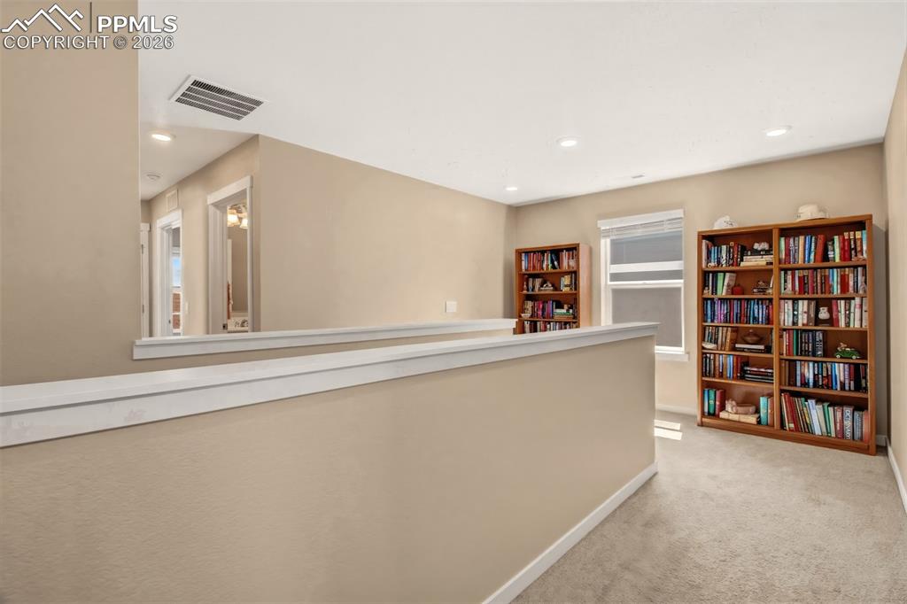 6133 Alpine Ridge Drive Colorado Springs, CO 80925 - Photo 14 of 31 a living room with cabinets and a book shelf
