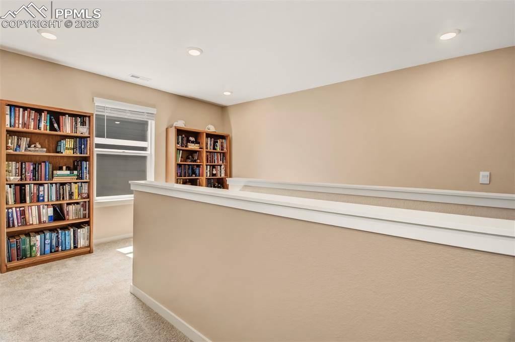 6133 Alpine Ridge Drive Colorado Springs, CO 80925 - Photo 15 of 31 a living room with a bookshelf and a book shelf