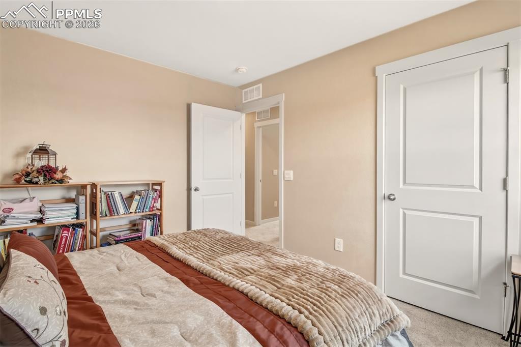 6133 Alpine Ridge Drive Colorado Springs, CO 80925 - Photo 21 of 31 a bedroom with a bed and a mirror