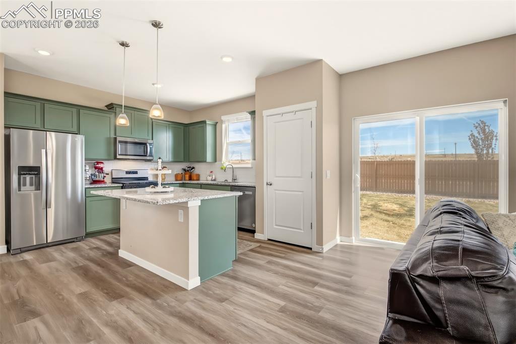 6133 Alpine Ridge Drive Colorado Springs, CO 80925 - Photo 4 of 31 a kitchen with a refrigerator a stove a sink dishwasher with a dining table and chairs
