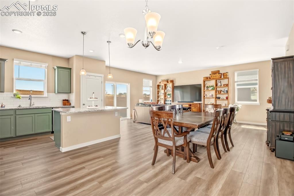 6133 Alpine Ridge Drive Colorado Springs, CO 80925 - Photo 8 of 31 a view of a dining room with furniture and wooden floor