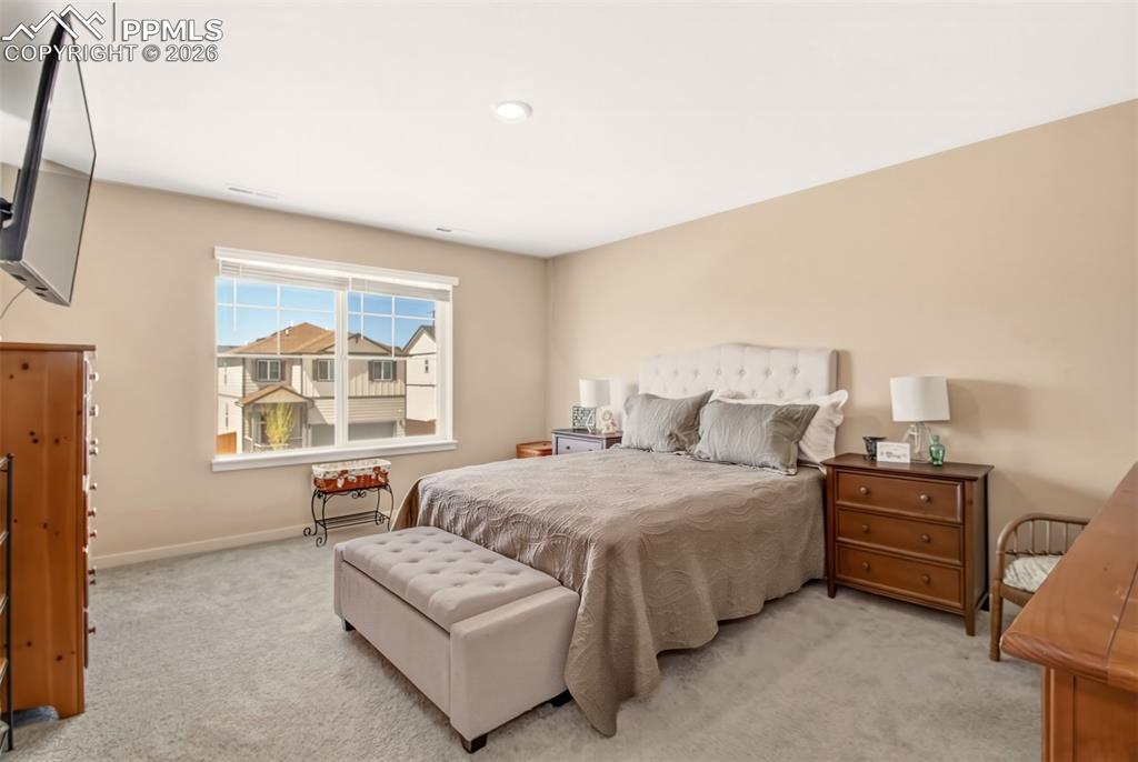 6133 Alpine Ridge Drive Colorado Springs, CO 80925 - Photo 9 of 31 a bedroom with a bed couch and a window