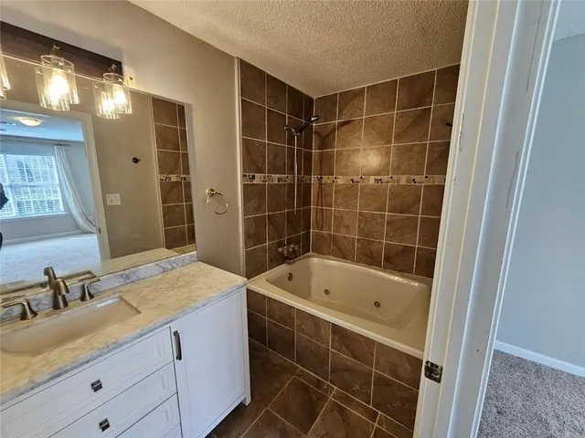a bathroom with a tub sink and mirror