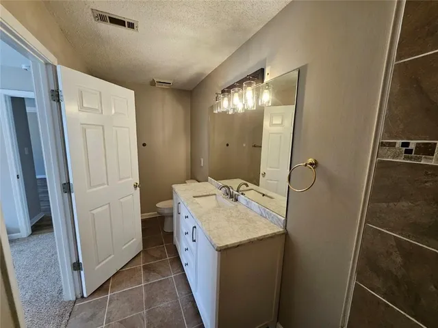 a bathroom with a sink a toilet and a mirror