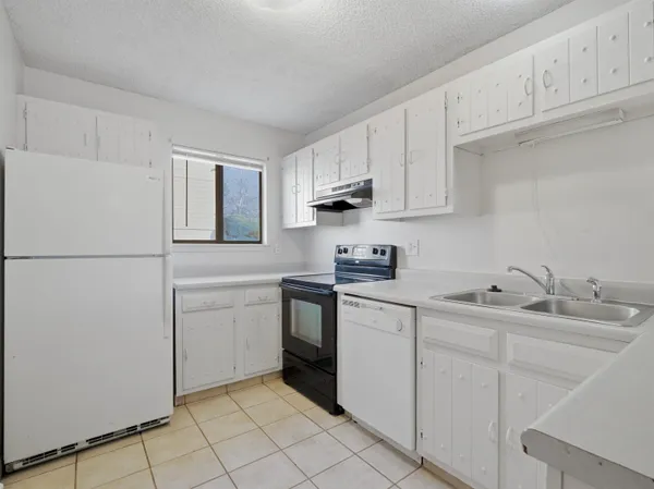 a kitchen with white cabinets sink and white appliances