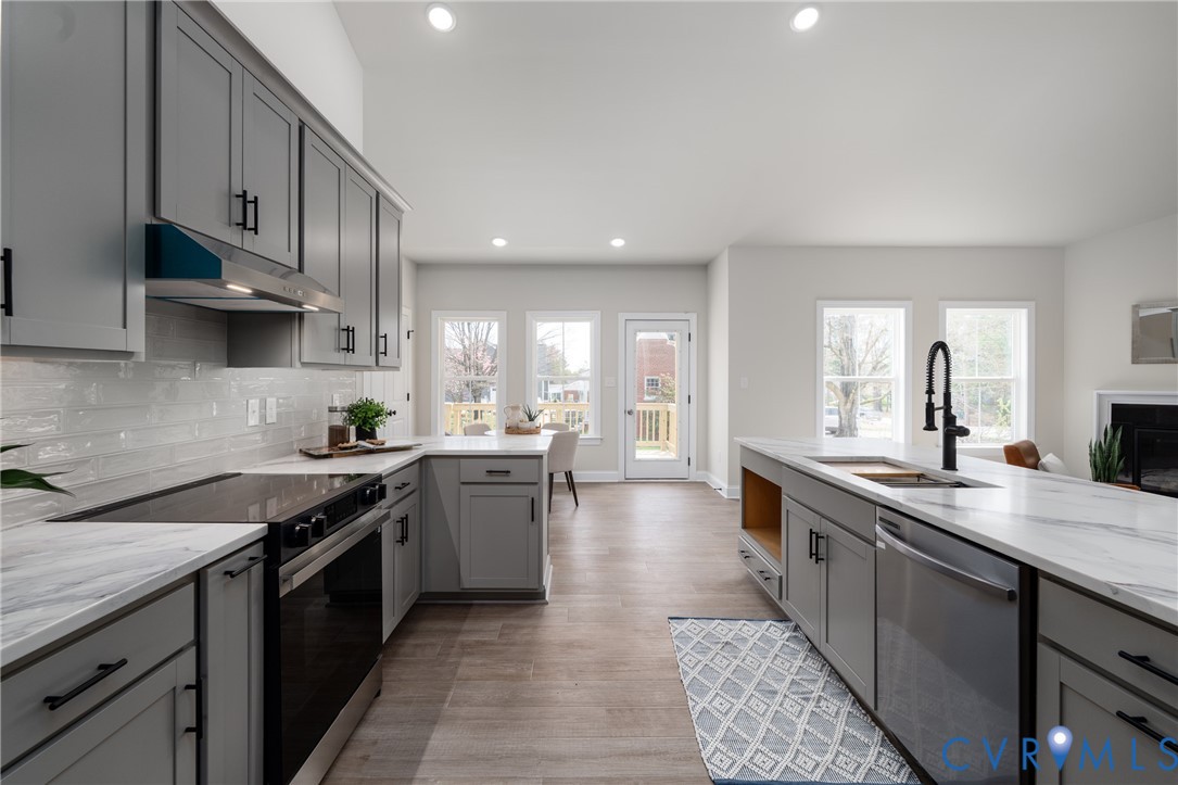 2301 Larkwood Road Henrico, VA 23294 - Photo 13 of 44 a kitchen with stainless steel appliances granite countertop a sink a stove and a wooden floors