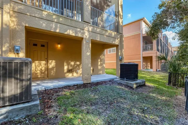 a view of a brick house with many windows next to a yard