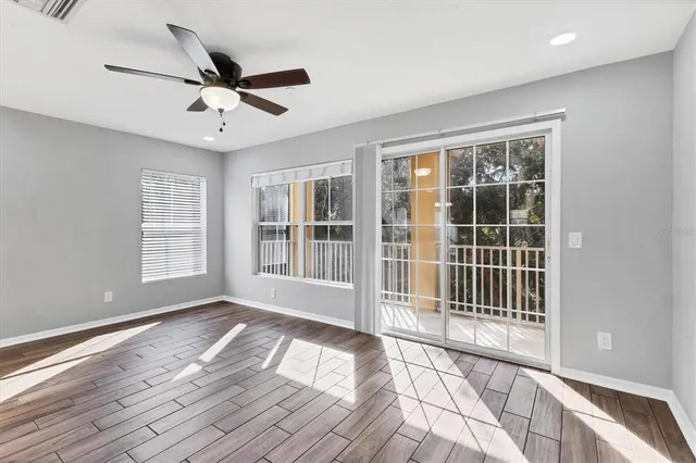 a view of empty room with wooden floor and fan