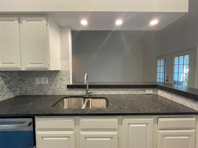 a view of a kitchen with a sink and wooden floor