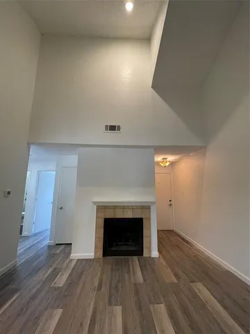 an empty room with wooden floor and fireplace