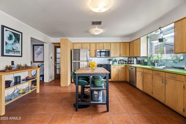 a open kitchen with stainless steel appliances granite countertop a stove top oven a sink dishwasher and cabinets with wooden floor