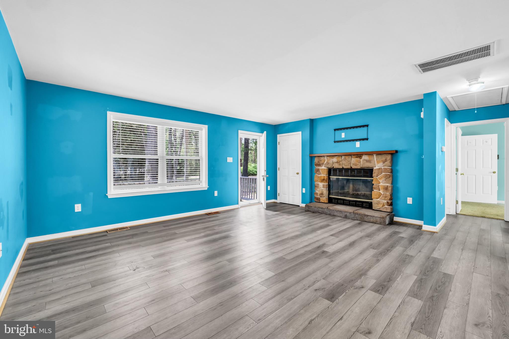 7392 Todds Wharf Road Preston, MD 21655 - Photo 10 of 63 an empty room with wooden floor fireplace and windows