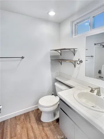 a bathroom with a granite countertop toilet and a sink