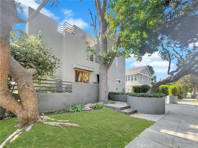 a front view of a house with a yard and a garden