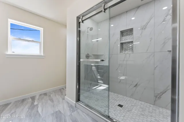 a bathroom with a glass shower door and a glass door