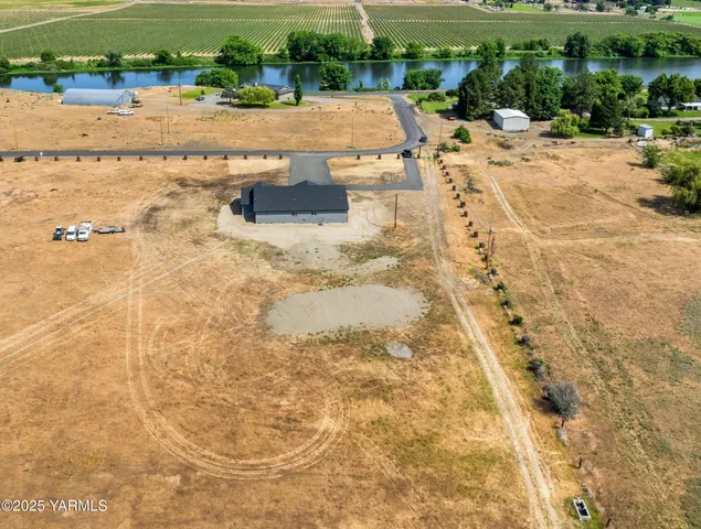 a view of a swimming pool with a yard and large trees