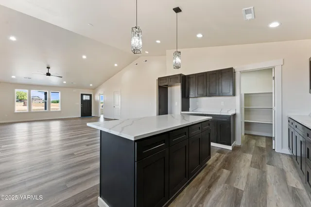 a kitchen with kitchen island a sink dishwasher stove and wooden floor