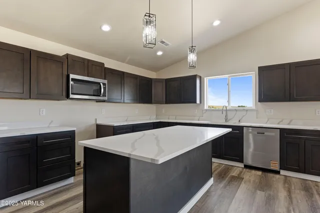 a kitchen with a sink a microwave and cabinets