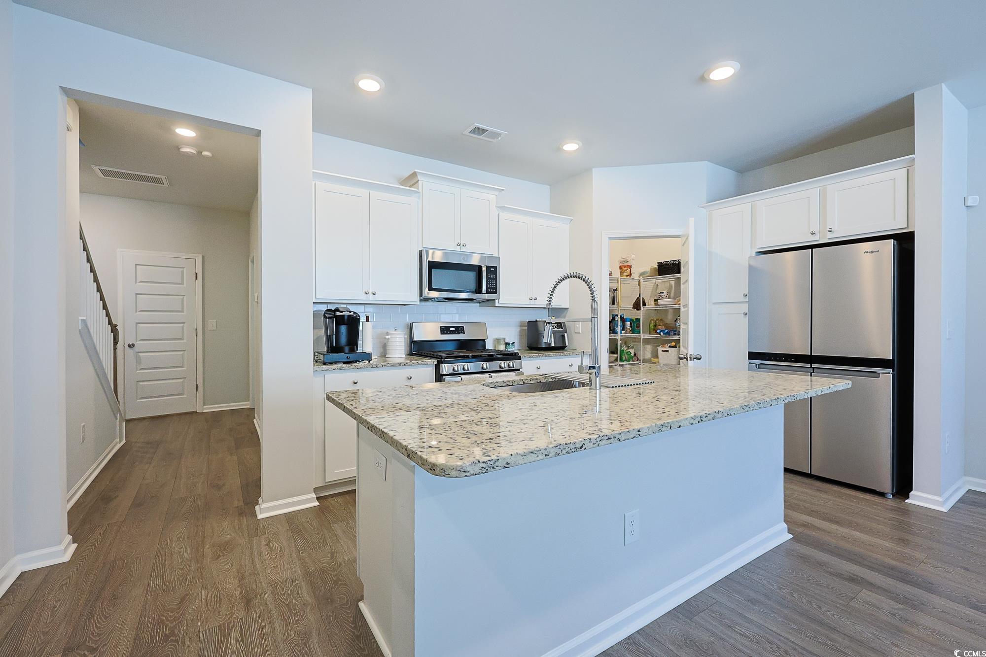5386 Knobcone Loop, Unit E Myrtle Beach, SC 29577 - Photo 15 of 34 Kitchen featuring tasteful backsplash, light stone countertops, stainless steel appliances, white cabinetry, and recessed lighting