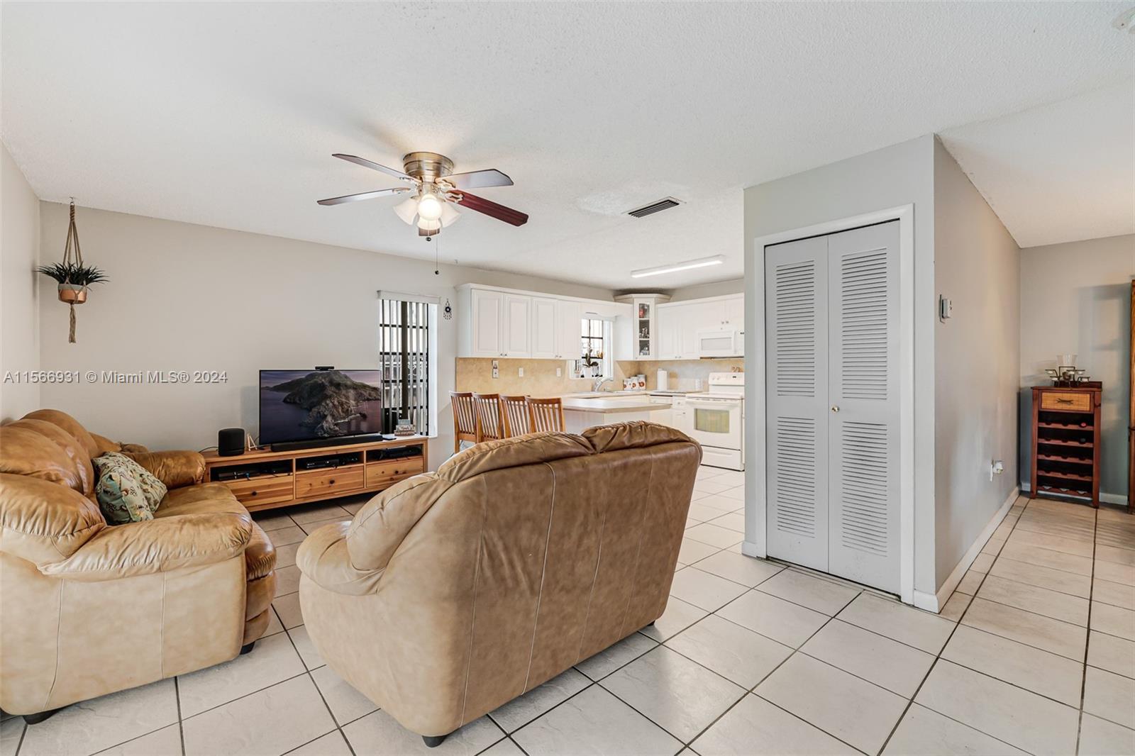 13202 Southwest 12th Lane Miami, FL 33184 - Photo 13 of 47 a living room with furniture and a flat screen tv