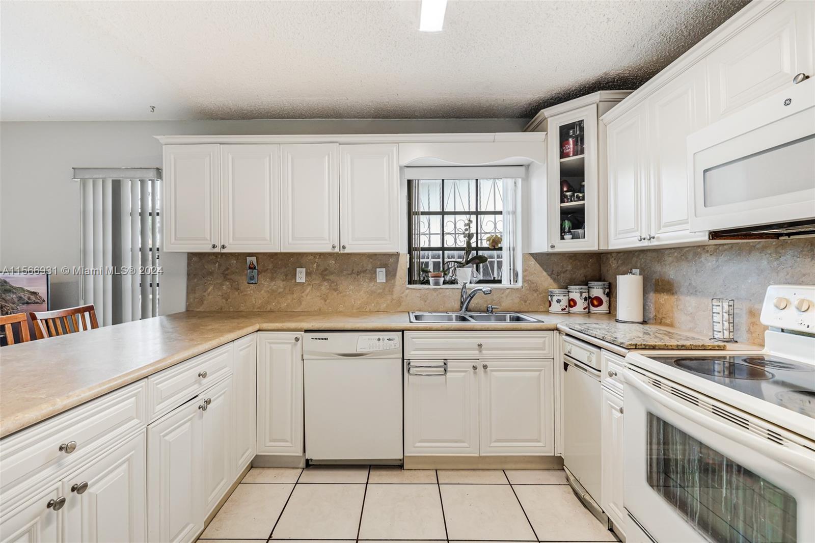 13202 Southwest 12th Lane Miami, FL 33184 - Photo 17 of 47 a kitchen with cabinets appliances a sink and a window