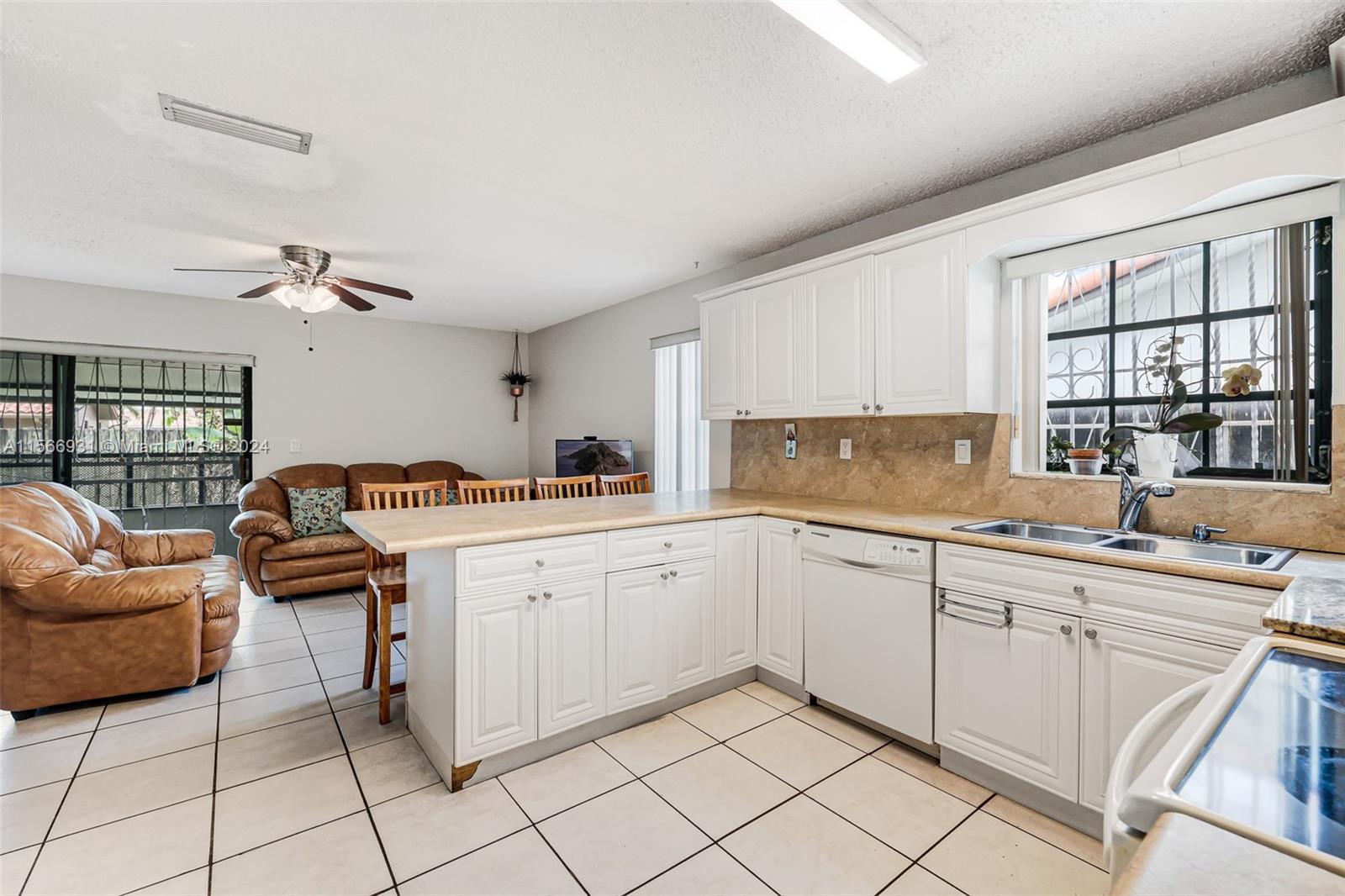 13202 Southwest 12th Lane Miami, FL 33184 - Photo 18 of 47 a kitchen with a sink and chairs
