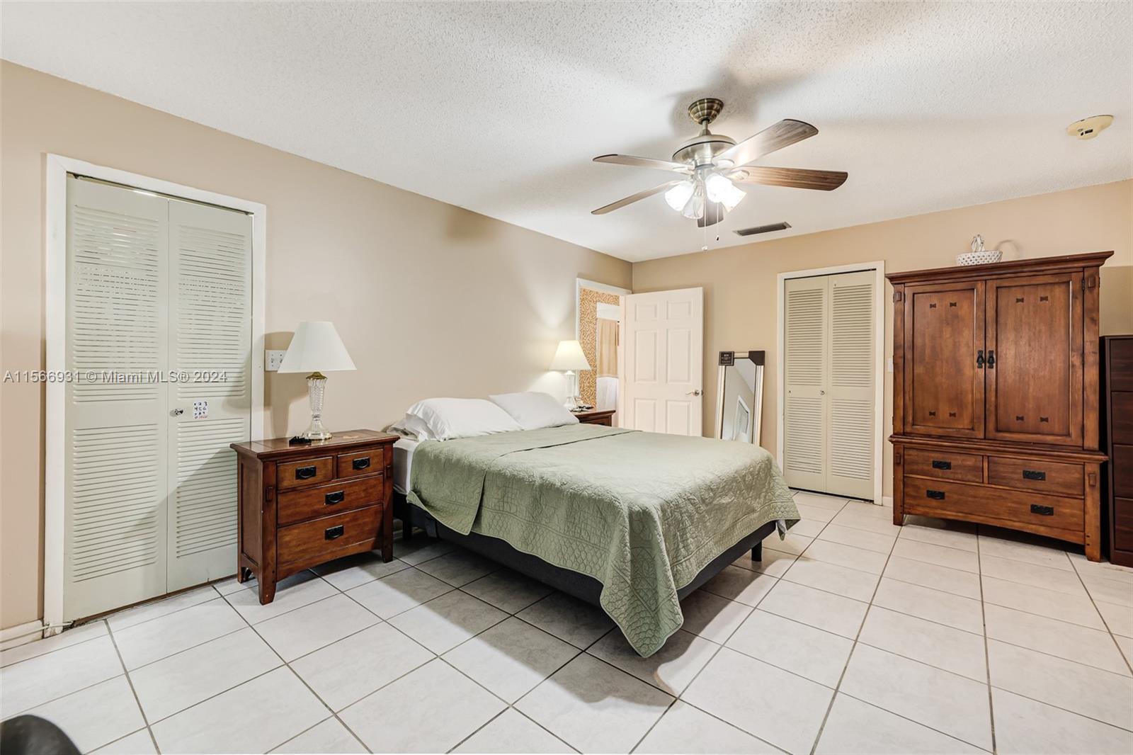 13202 Southwest 12th Lane Miami, FL 33184 - Photo 22 of 47 a spacious bedroom with a bed and a cabinets
