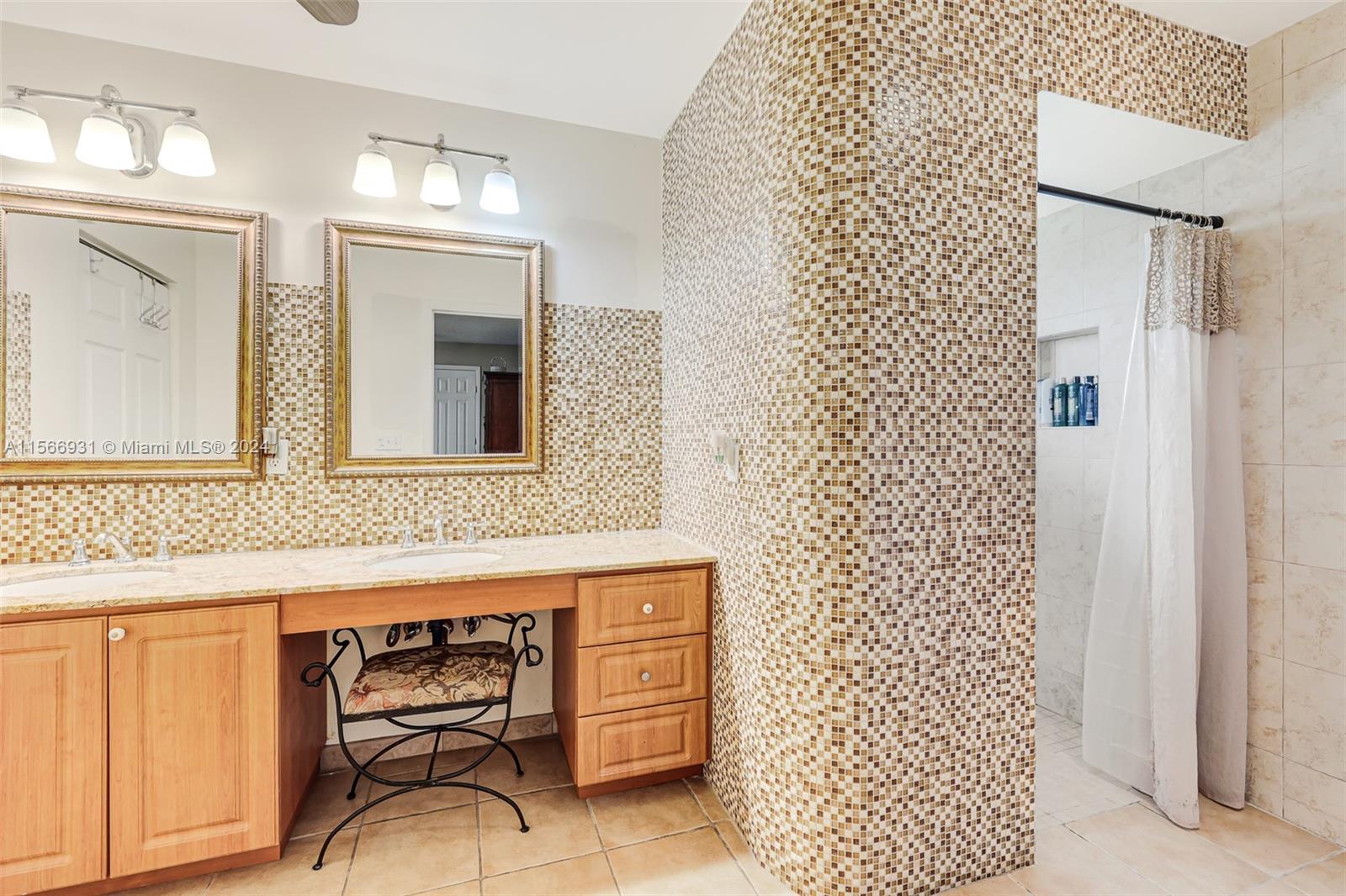 13202 Southwest 12th Lane Miami, FL 33184 - Photo 24 of 47 a bathroom with a sink a mirror and a shower