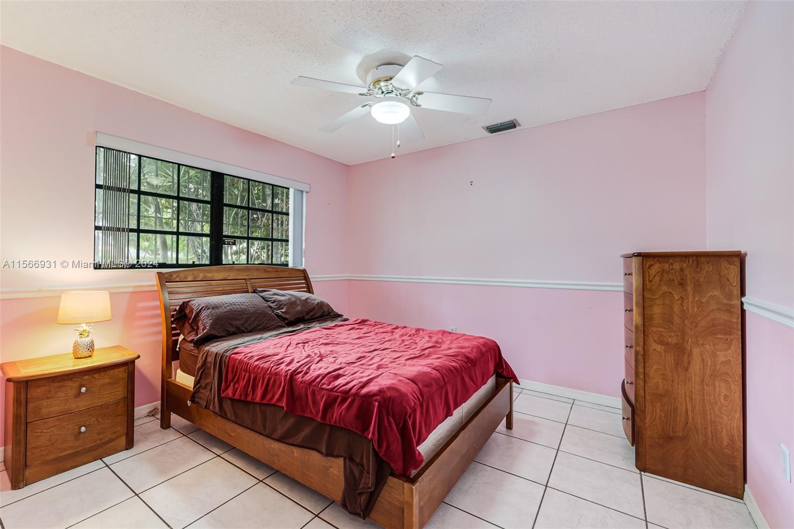 13202 Southwest 12th Lane Miami, FL 33184 - Photo 27 of 47 a bedroom with a bed and window