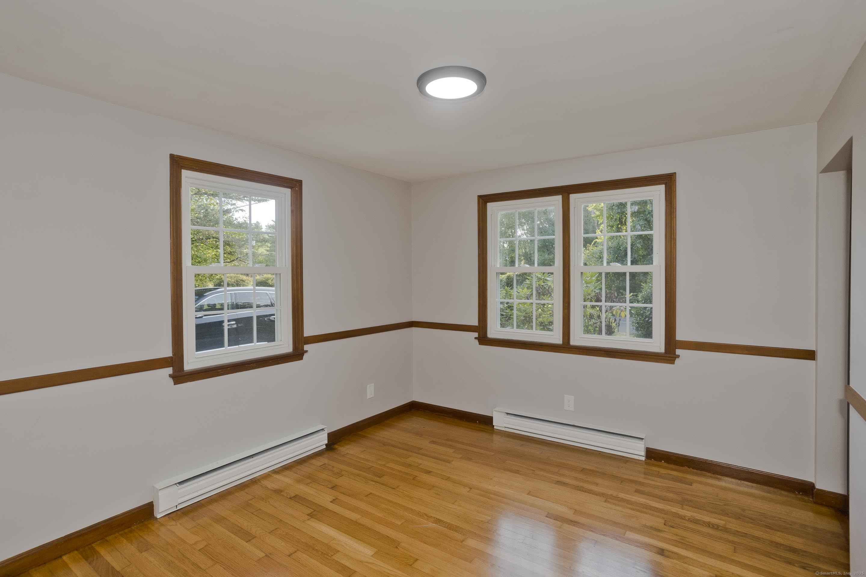 215 Sand Dam Road Thompson, CT 06277 - Photo 11 of 36 a view of an empty room with wooden floor and a window