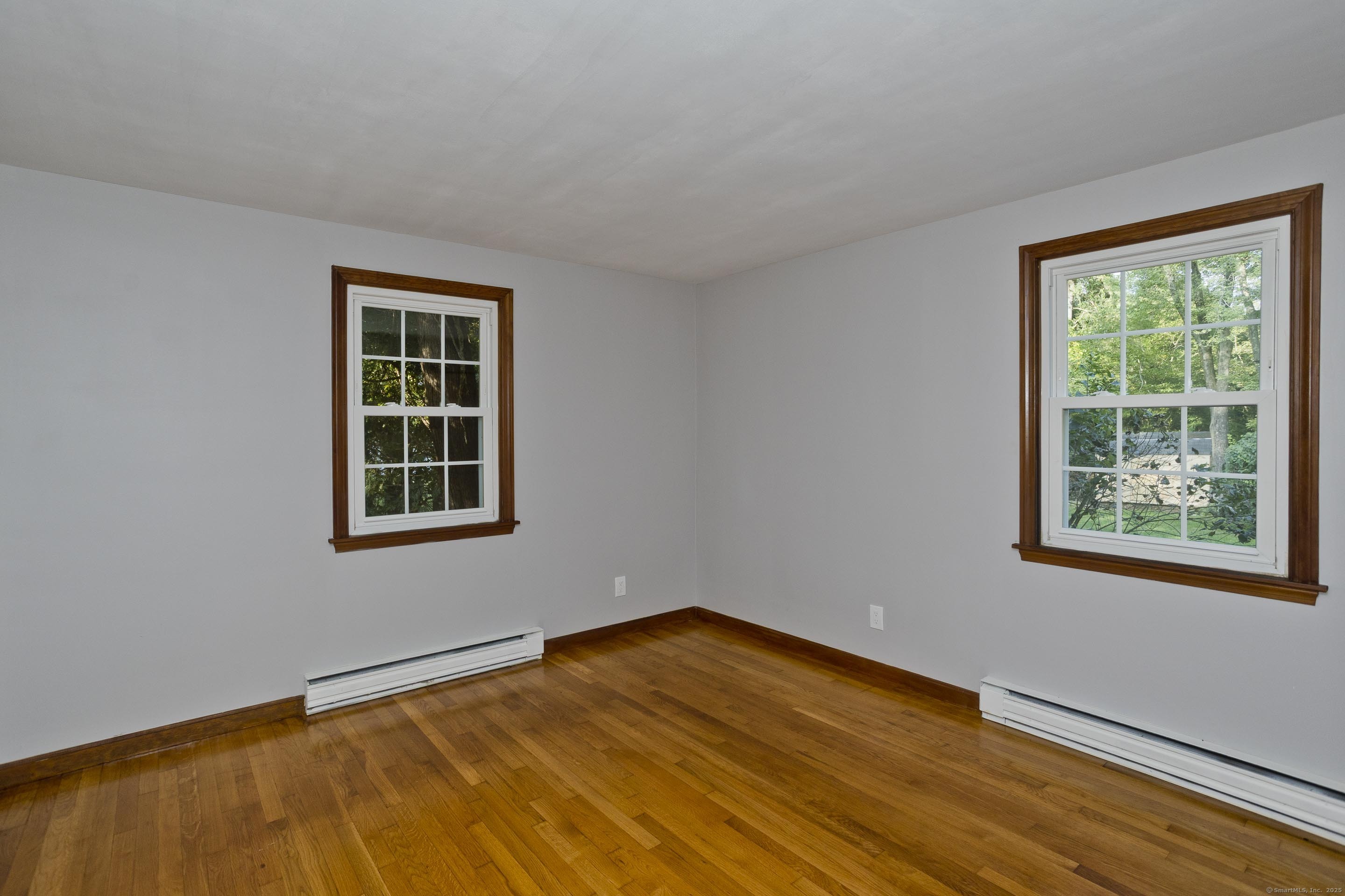 215 Sand Dam Road Thompson, CT 06277 - Photo 15 of 36 a view of an empty room with a window and wooden floor