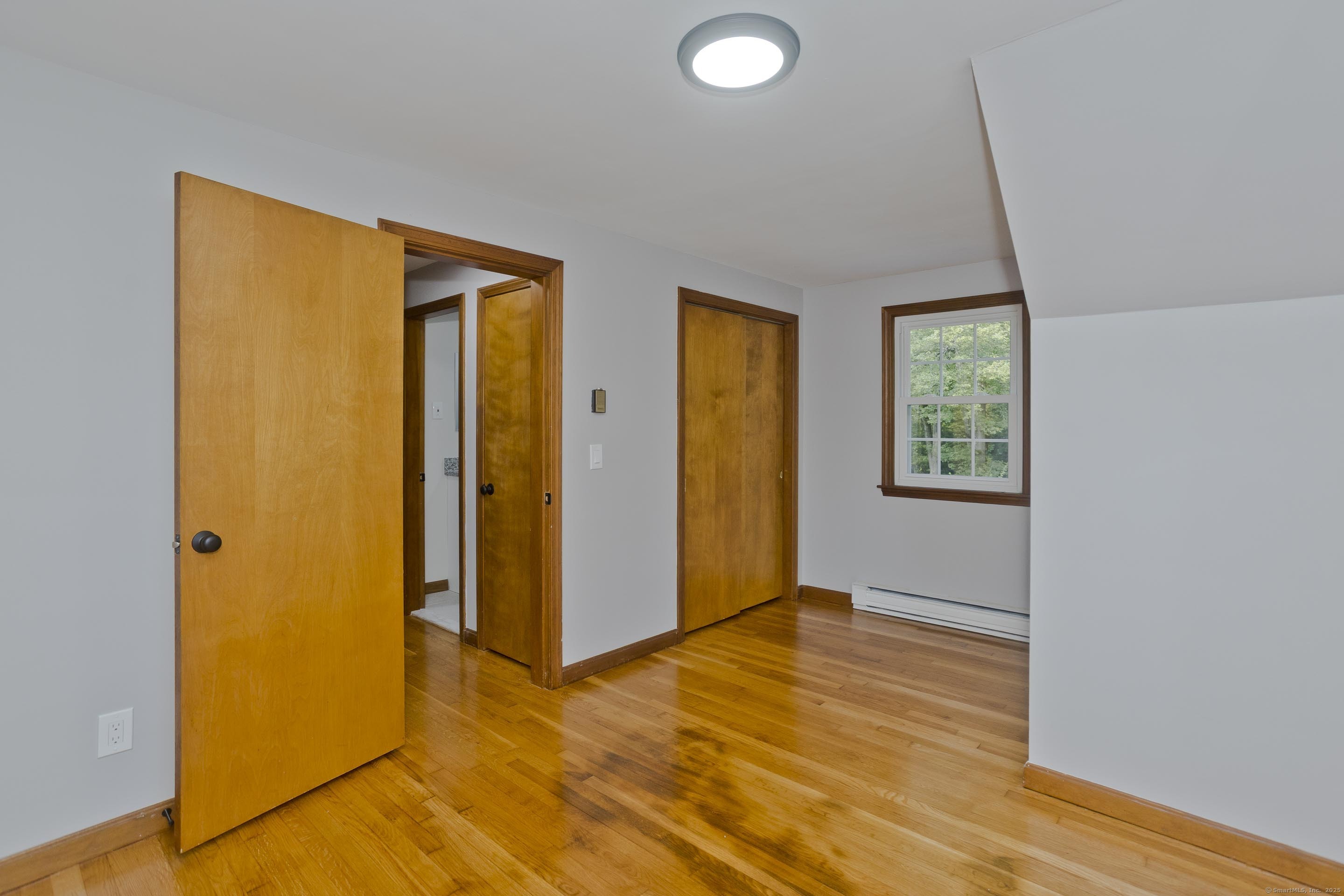 215 Sand Dam Road Thompson, CT 06277 - Photo 22 of 36 a view of an empty room with window and wooden floor