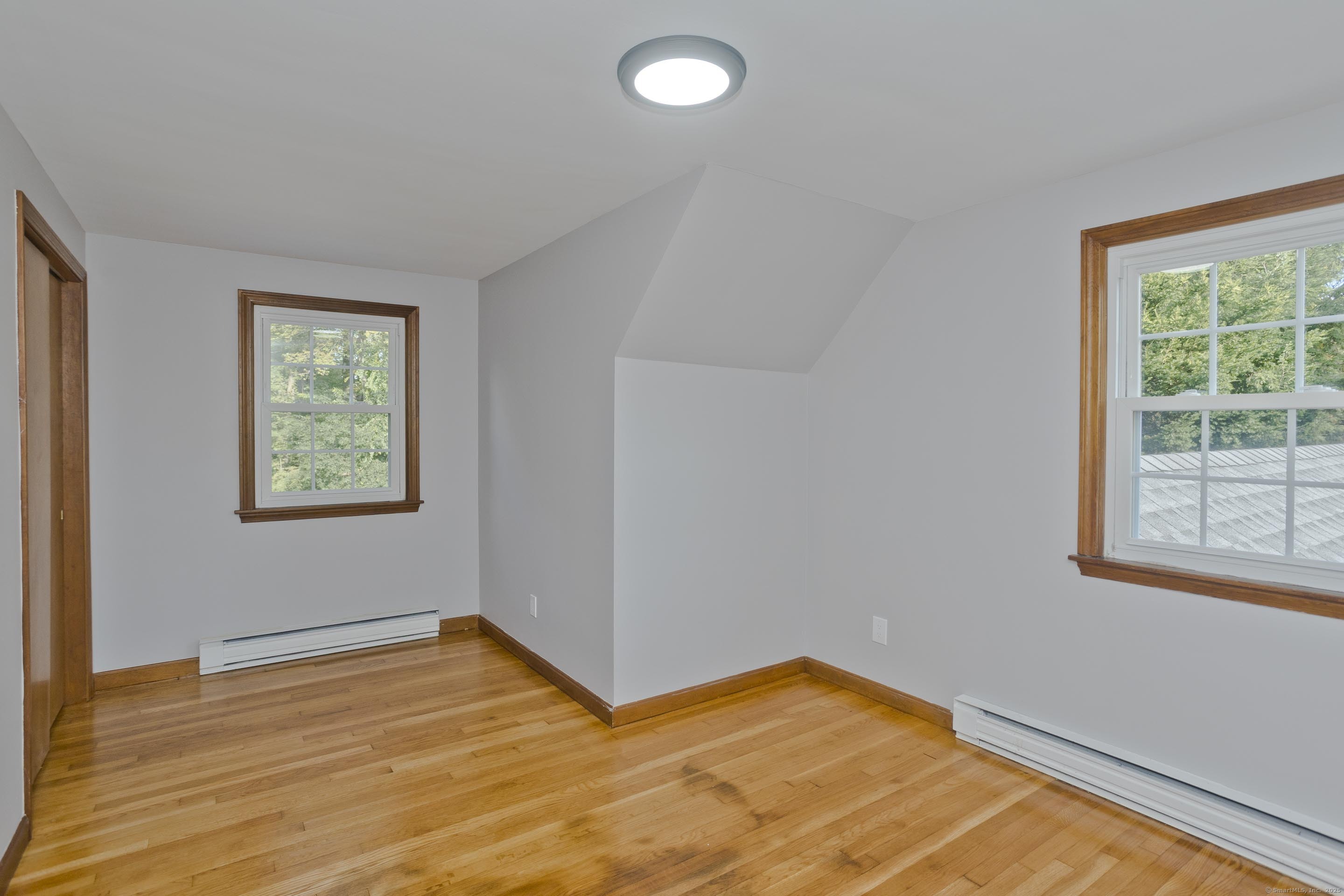 215 Sand Dam Road Thompson, CT 06277 - Photo 23 of 36 a view of an empty room with wooden floor and a window