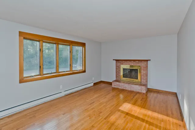 a view of an empty room with glass door and wooden floor