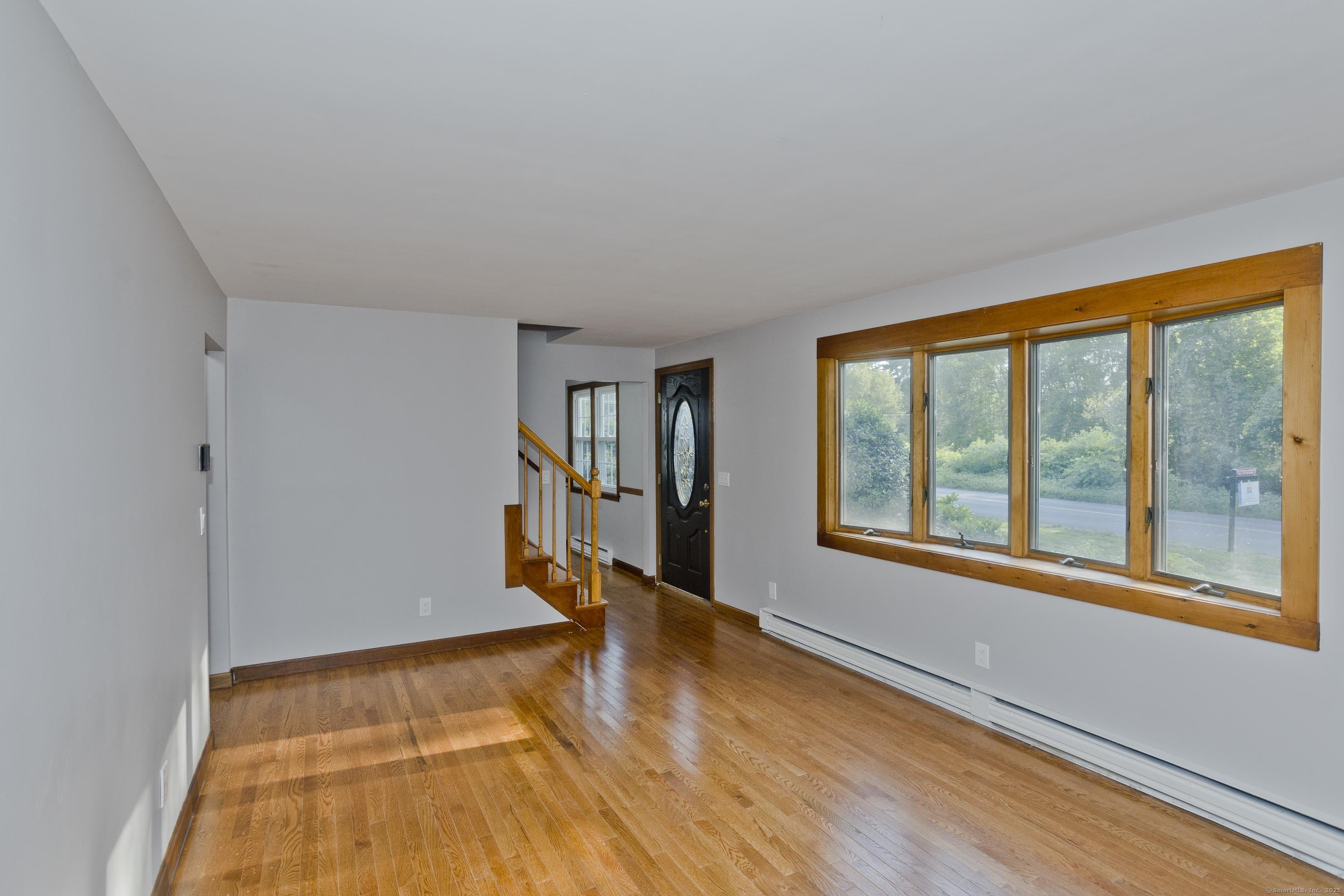 215 Sand Dam Road Thompson, CT 06277 - Photo 5 of 36 a view of an empty room with wooden floor and a window