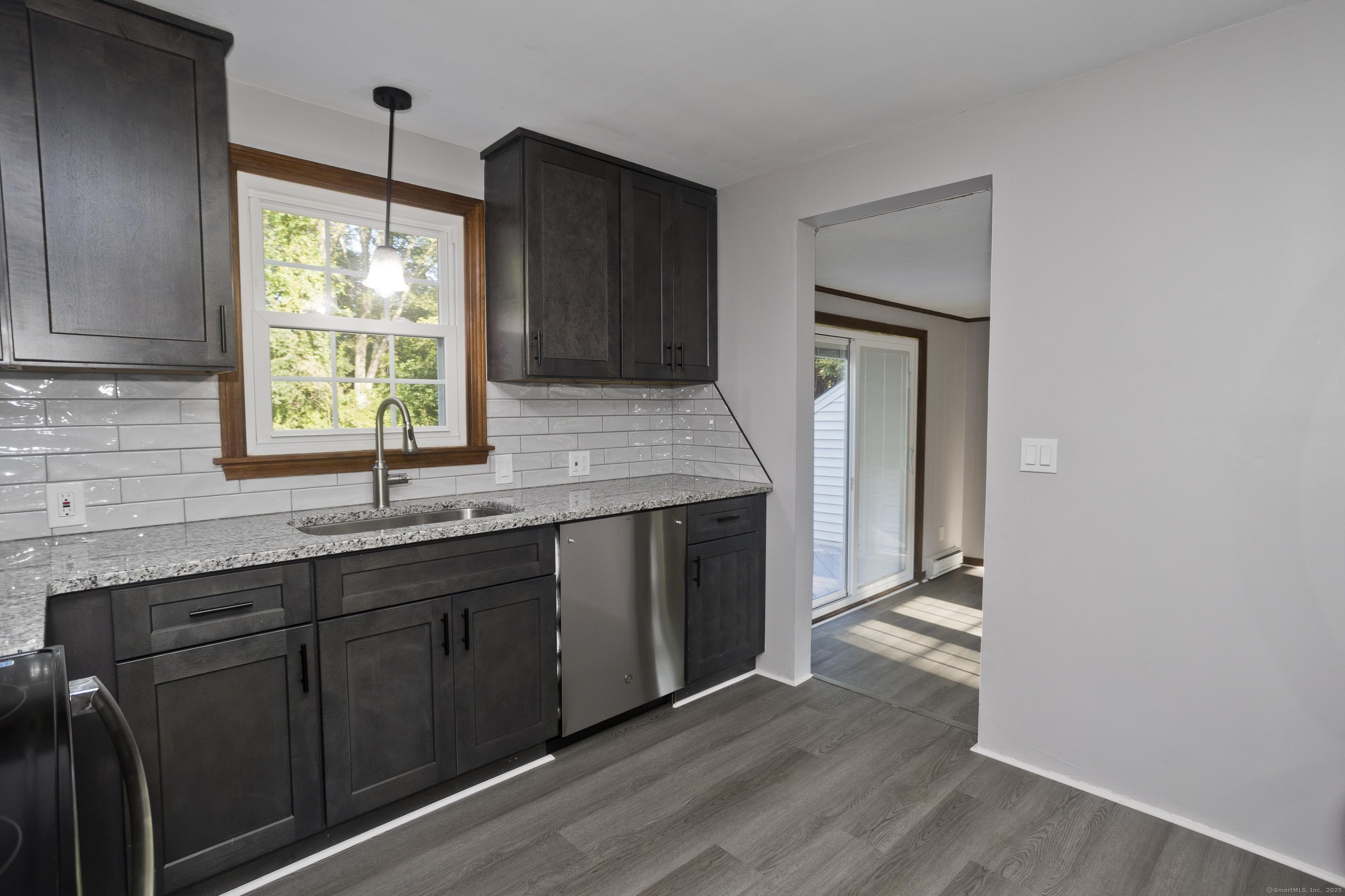 215 Sand Dam Road Thompson, CT 06277 - Photo 9 of 36 a kitchen with stainless steel appliances granite countertop wooden cabinets a sink and a window