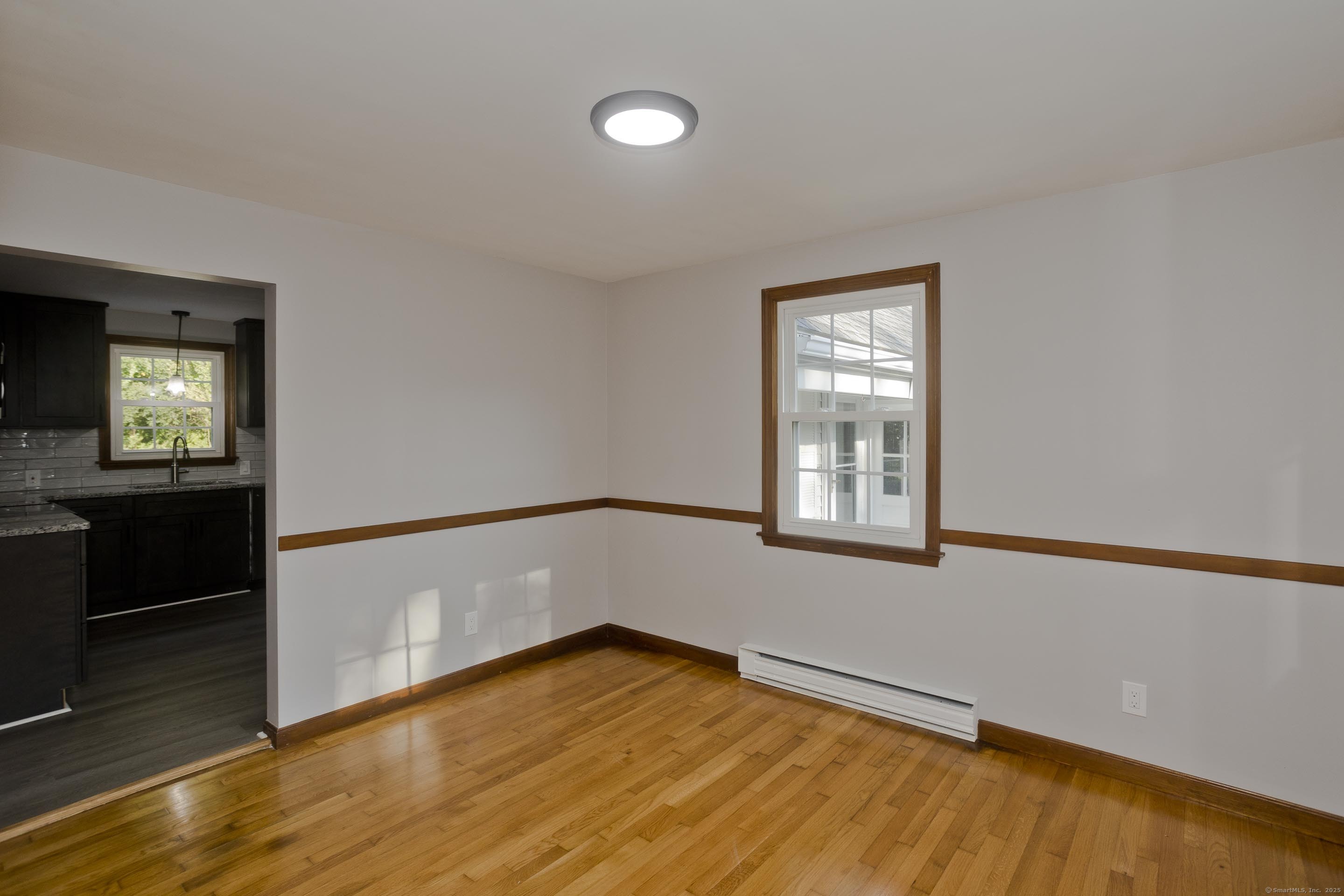 215 Sand Dam Road Thompson, CT 06277 - Photo 10 of 36 a view of an empty room with wooden floor and a window