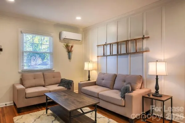 a living room with furniture a rug and a window