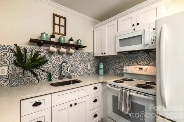a kitchen with white cabinets and appliances