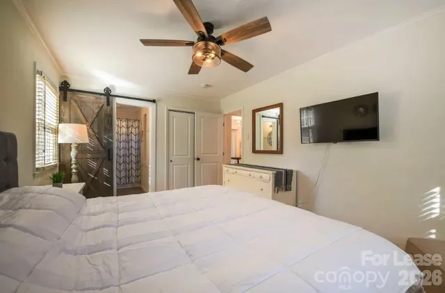 a bedroom with a large bed and a flat screen tv