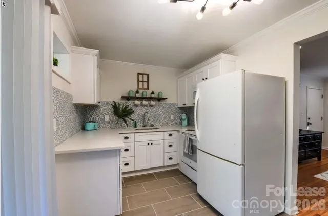 a kitchen with stainless steel appliances a refrigerator sink and white cabinets